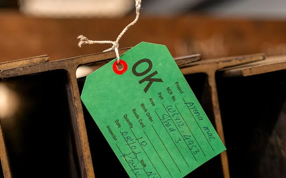 An inspection tag against stacked steel.