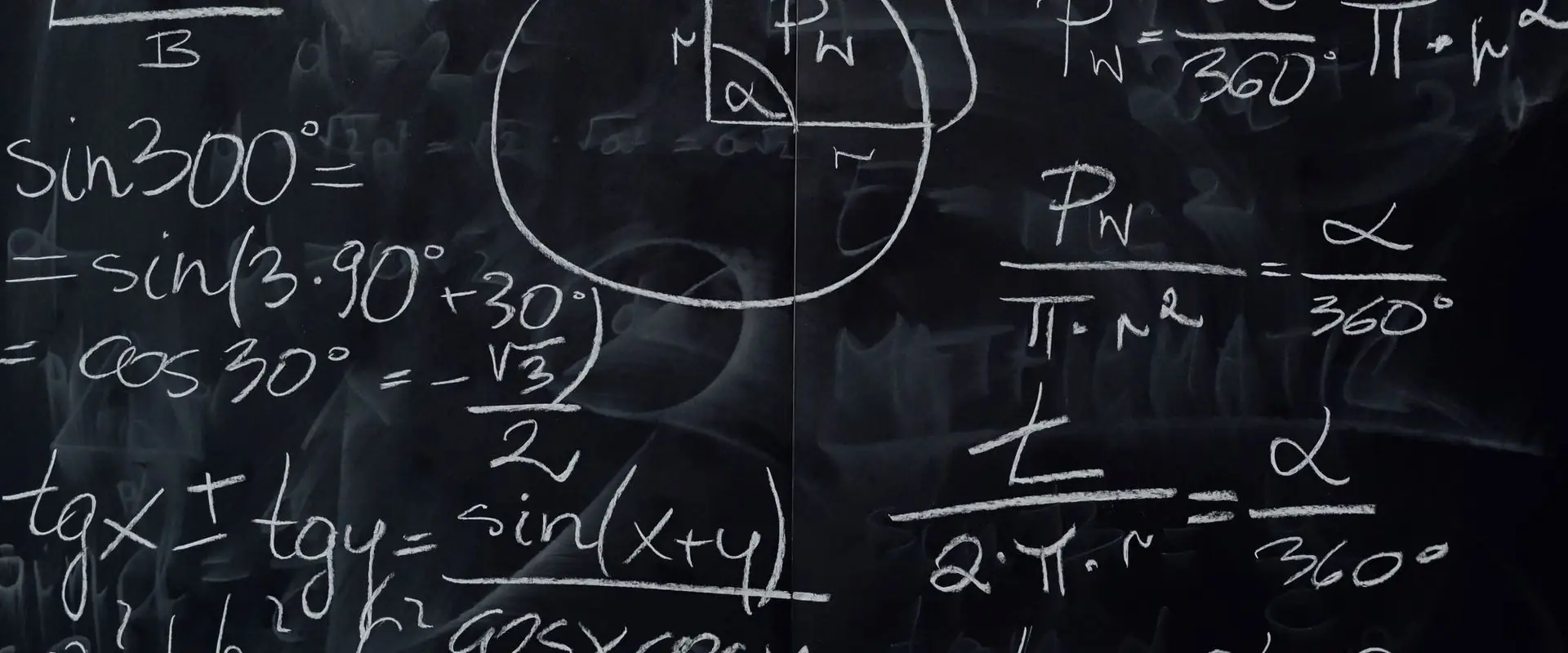 Close chalk working on a blackboard, numbers and fractions.